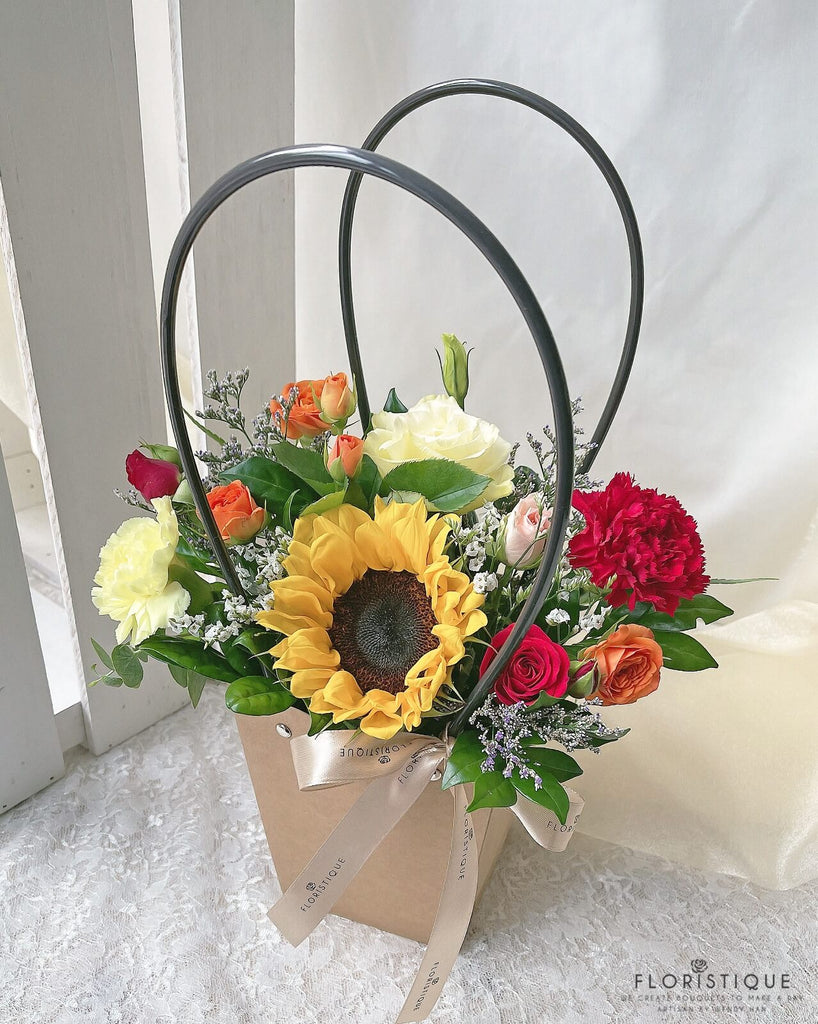 Clarabelle FBS:  Sunflower, Roses, Spray roses, Eustoma, Carnations Flower Bag